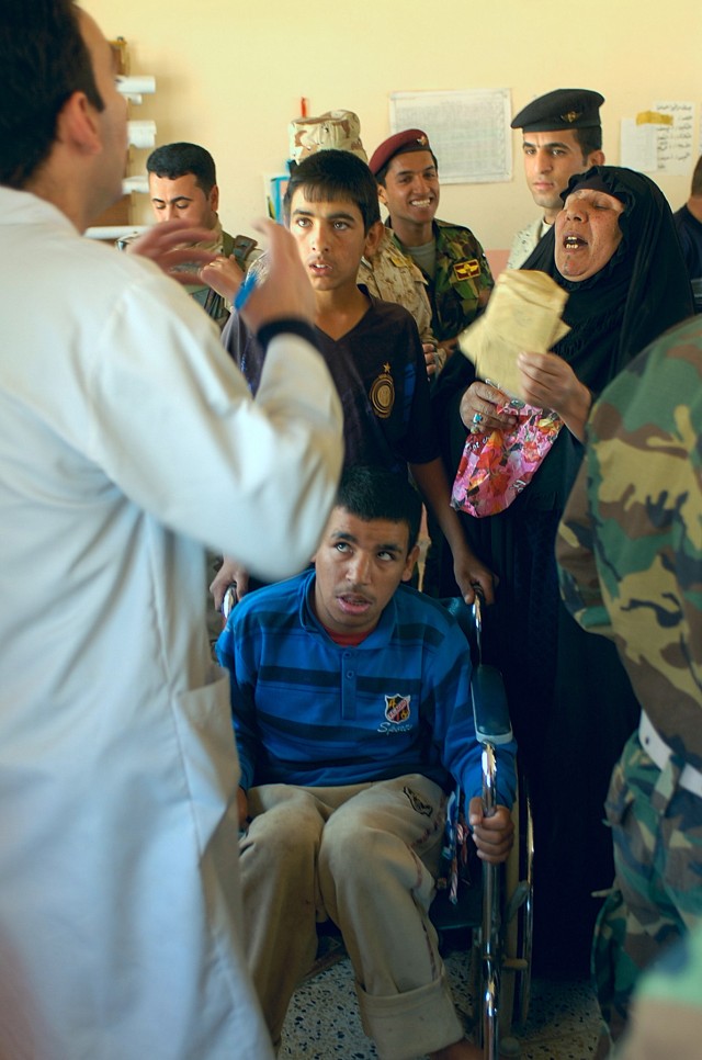 BAGHDAD-A mother converses with an Iraqi medical volunteer about how to go about getting her son a new wheel chair. The 11th Iraqi Army Division gave away five wheel chairs during their first humanitarian visit to the small, poverty stricken...