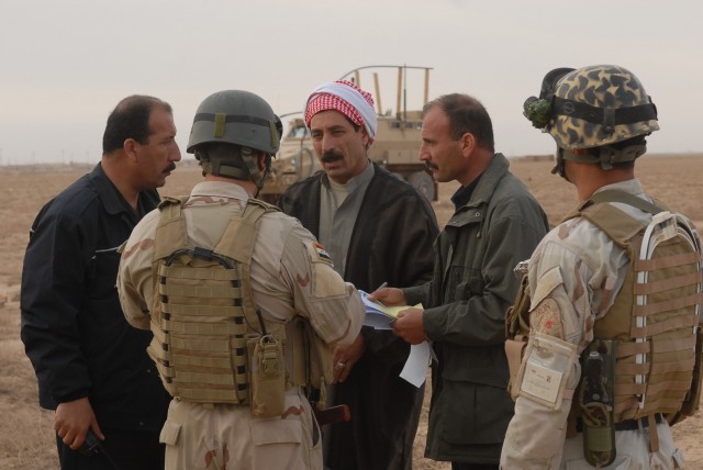 Iraqi Police and Iraqi Army talk to the village leader, known as a Muktar, during operation "Dark Horse Cossack Two" March 15. The operation was conducted in the village of Yourgun, Kirkuk, Iraq, and was lead by IA and IP with assistance from U.S....