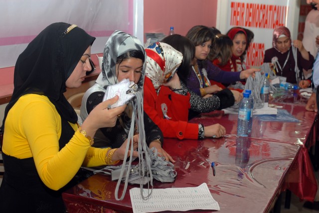 Women involved with the planning and execution of a conference in Narwooz Hall in Kirkuk city, Iraq, March 14 pass out badges to guests as they enter. The goal of the conference was to improve the status of women's rights and the political power...