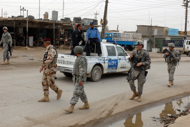 Iraqi Army, Iraqi Police and U.S. Soldiers establish security while other Soldiers and IAs make the last Coalition Forces backed payment to the Sons of Iraq in the city of Zaab March 3. This is one of many different missions that Soldiers from 1st...