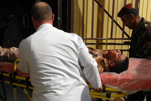 Doctors and emergency services personnel bring a simulated casualty into the Kirkuk Military Base, Kirkuk, Iraq, during a mass casualty training exercise Feb. 24. The participants are learning how to save lives during mass casualty events. The...