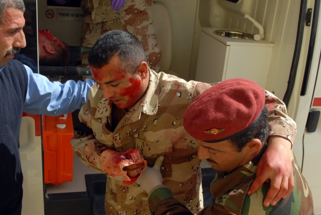 Participants in a mass casualty training exercise at Kirkuk Military Base, also known as K-1 in Kirkuk, Iraq, bring a casualty into the medical clinic Feb. 24. The participants are practicing skills they learned during a 17 day combat life saver...