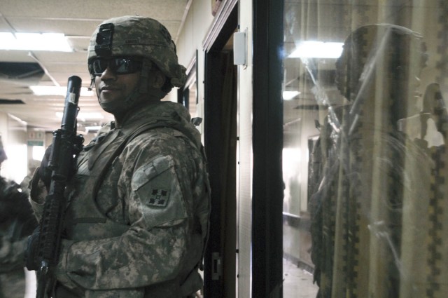 Pfc. Spencer Smoot, the medic for 3rd Platoon, C Company, 1st Battalion, 67th Armor Regiment, 2nd Brigade Combat Team, 4th Infantry Division is reflected in the cracked glass of a window in the Alsalam Hospital in Mosul, Iraq. C Co. and the Mosul Rec...