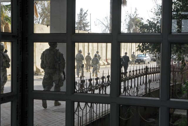 Soldiers with 3rd Platoon, C Company, 1st Battalion, 67th Armor Regiment, 2nd Brigade Combat Team, 4th Infantry Division are seen through the freshly replaced windows of the Alsalam Hospital entrance in Mosul, Iraq. C Co. coordinated with the Mosul R...