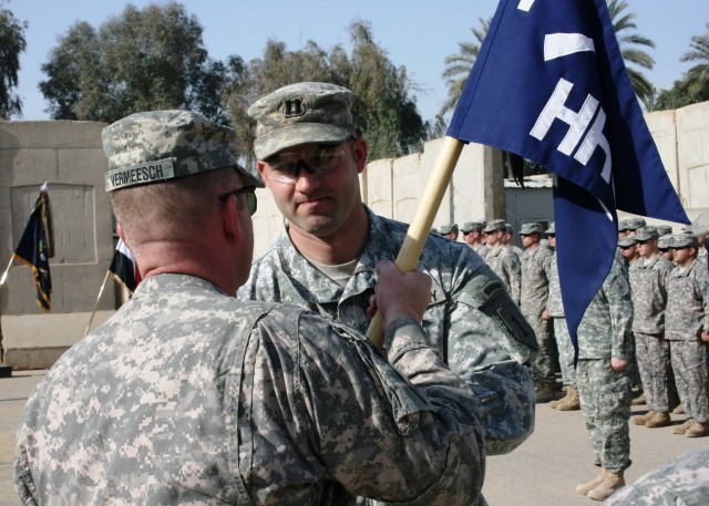 BAGHDAD - Lt. Col. John Vermeesch (left), a native of Marshall, Mich., commander, 1st Combined Arms Battalion, 18th Infantry Regiment, passes the Headquarters and Headquarters Company guidon to Capt. Clint Olearnick, a native of Parker, Colo., comman...