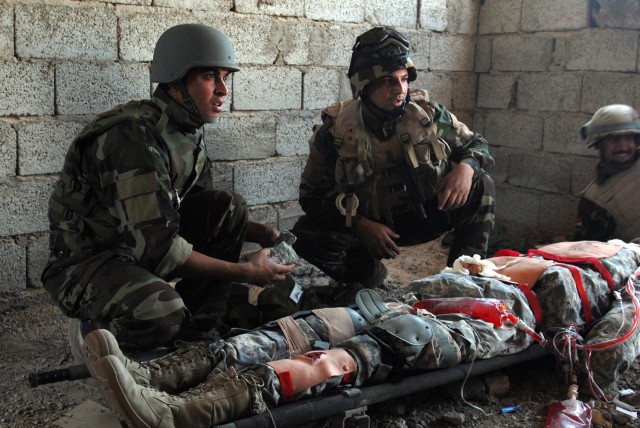 BAGHDAD - Soldiers with the 6th Iraqi Army Division prepare to treat wounds on a medical dummy constructed by Sgt. 1st Class Victor Orozco, Karkh Area Command liaison, 6th IA Div. Military Transition Team. The Fort Carson, Colo. native fitted the dum...
