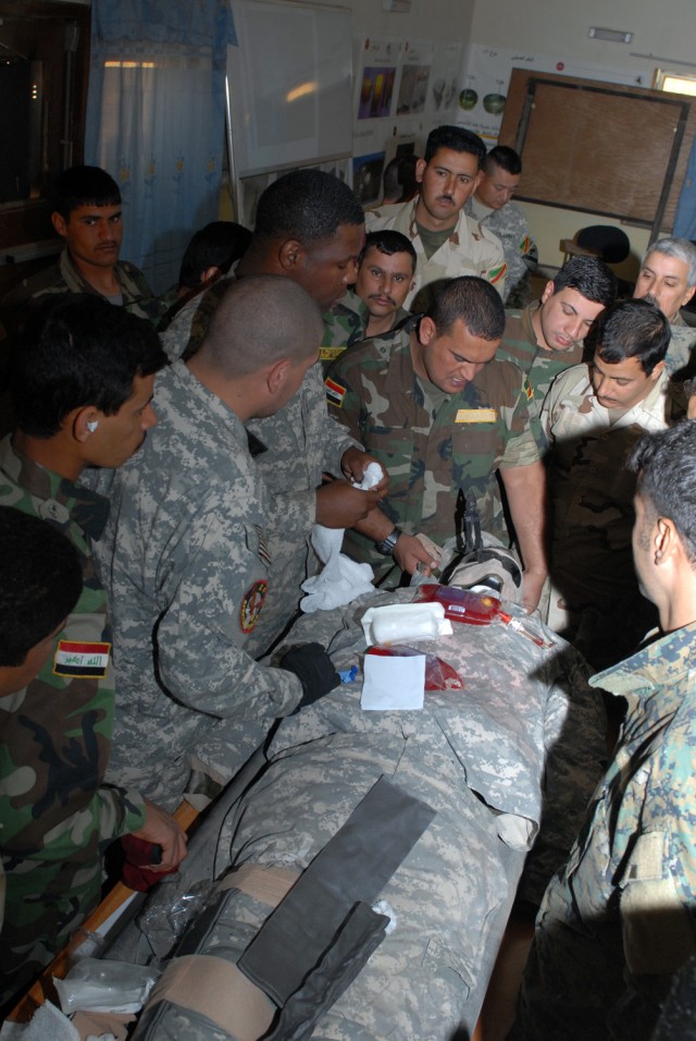 BAGHDAD - Iraqi Soldiers of 6th Iraqi Army Division gather round "Woody," a medical dummy constructed of various leftover materials by Sgt. 1st Class Victor Orozco, Karkh Area Command liaison, 6th IA Div. Military Transition Team. One of Woody's many...