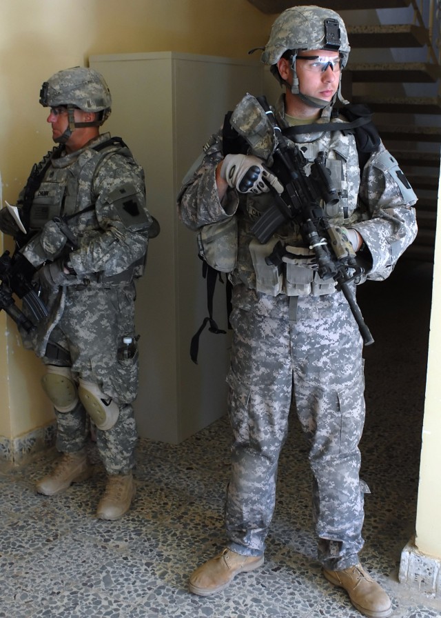 BAGHDAD - Spc. Mark Cameron (right), 2nd Stryker Battalion, 112th Infantry Regiment, 2nd Heavy Brigade Combat Team, 1st Infantry Division, Multi-National Division-Baghdad, posts watch at a building in Abu Ghraib, Iraq March 23. The Stryker...