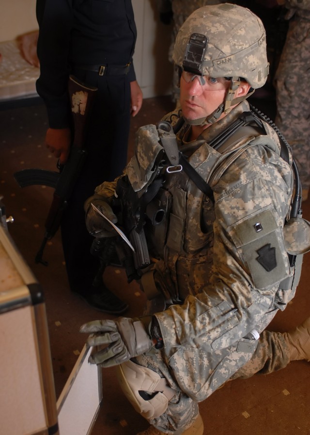 BAGHDAD - Staff Sgt. Ronald Chun, 2nd Stryker Battalion, 112th Infantry Regiment, 2nd Heavy Brigade Combat Team, 1st Infantry Division, Multi-National Division-Baghdad, searches a room for possible weapons or explosives in Abu Ghraib, Iraq March...