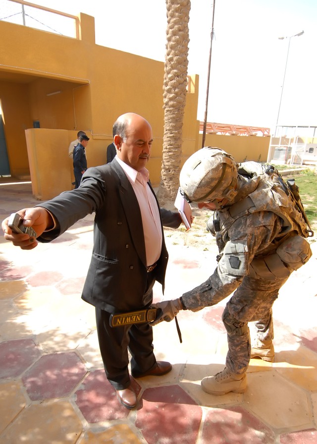 BAGHDAD - Army Staff Sgt. Fredrick Waine, 2nd Stryker Battalion, 112th Infantry Regiment, 2nd Heavy Brigade Combat Team, 1st Infantry Division, Multi-National Division-Baghdad, searches an Iraqi civilian in Abu Ghraib, Iraq March 23. The Soldiers...