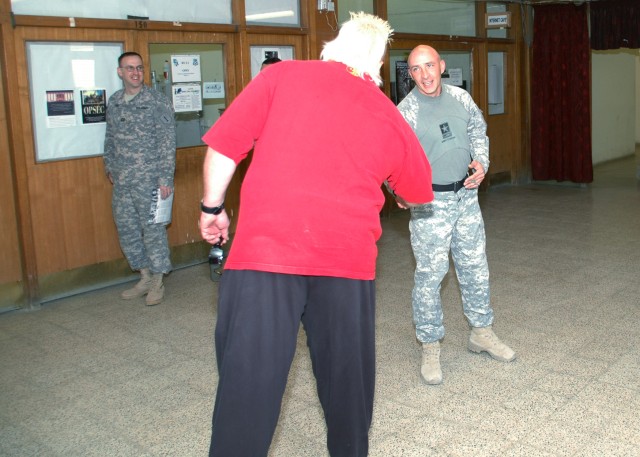 BAGHDAD - Brian "Nasty Boy" Knobs, a member of the "Legends of Wrestling Tour," shakes the hand of Command Sgt. Maj. Jeffrey Smith, senior enlisted leader, 1st Combined Arms "Vanguard" Battalion, 18th Infantry Regiment at Forward Operating Base...