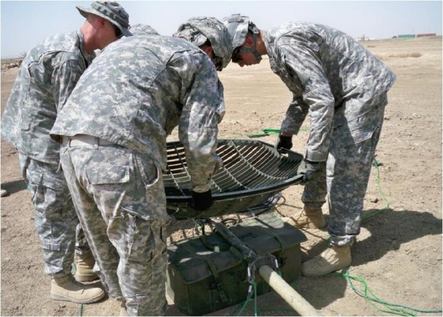 Sgt. Jody Tripp teaches Pfc. Jonathan Josd and Pfc. Mark Cichoracki, Soldiers with the 4th Special Troops Battalion, 4th Brigade Combat Team, 1st Cavalry Division, how to properly install the15M-mast satellite dish to provide optimal coverage for...