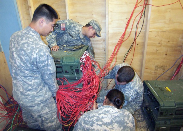 BAGHDAD - Soldiers from the 2nd Platoon "Knights" Joint Network Node 7768, Brigade Special Troops Battalion, 2nd Heavy Brigade Combat Team, 1st Infantry Division, Multi-National Division -- Baghdad, work as a team to troubleshoot one of the...