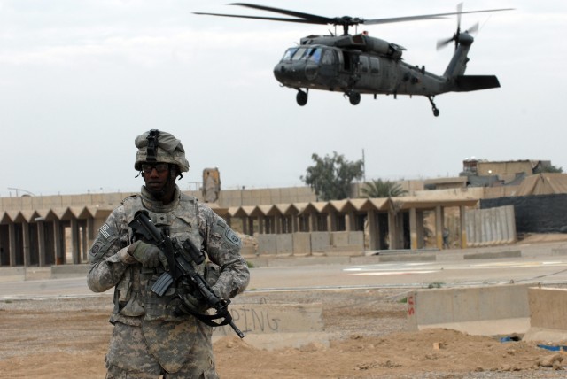 BAGHDAD - Spc. Hubert Brazile, a paratrooper assigned to the 3rd Brigade Combat Team, 82nd Airborne Division, provides security as Maj. Gen. Daniel Bolger, commander of Multi-National Division - Baghdad, lands in a UH-60 Black Hawk helicopter to atte...