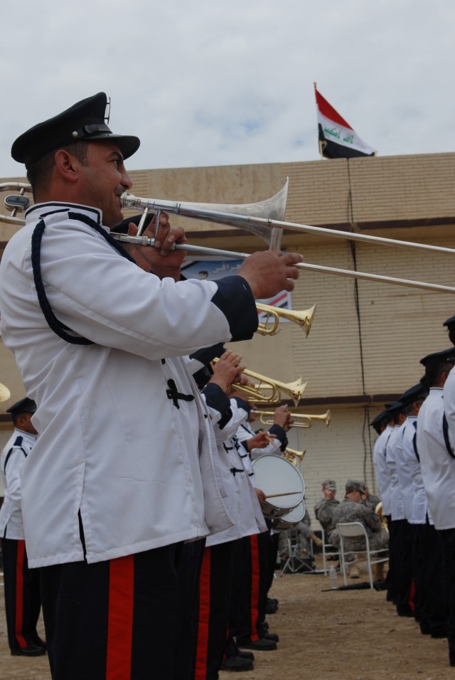 BAGHDAD - Iraqi Military Academy - Rustamiyah band plays during a ceremony to transfer Forward Operating Base Rustamiyah back over to Iraqi officials here March 31. The 1st Cavalry Division band sits in the background waiting their opportunity to pla...