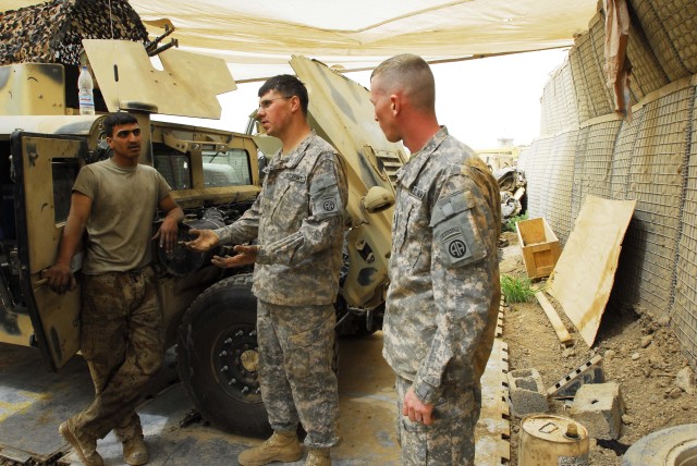 BAGHDAD - Mechanics Staff Sgt. Denis Mcfall, who hails from Point Pleasant, W. Va. and Marietta, Ohio native, Sgt. Robert Knotts, both from Company E, 1st Battalion, 505th Parachute Infantry Regiment, discuss vehicle maintenance with Iraqi Army...