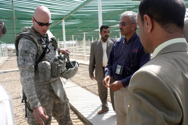 1st Lt. Devens Vogt, a civil capacity officer for 14th Engineer Battalion, guides local Dhi Qar politicians and Provincial Council members on a tour of the Nasiriyah Tree Nursery during its opening ceremony March 26. The nursery has two...