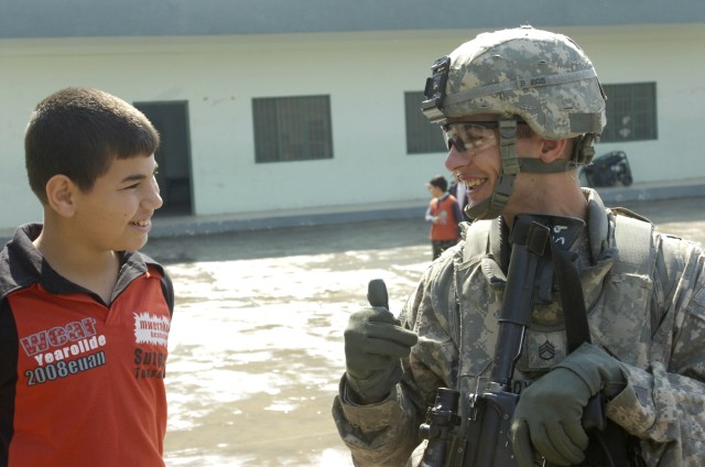 BAGHDAD -Staff Sgt. Sean Boyd, of Detroit, Mich., gives a thumbs up sign to an Iraqi boy during a distribution event April 1 in the area of Sumer al-Ghadier, located in the 9 Nissan district of eastern Baghdad. Boyd, and Paratroopers assigned to...