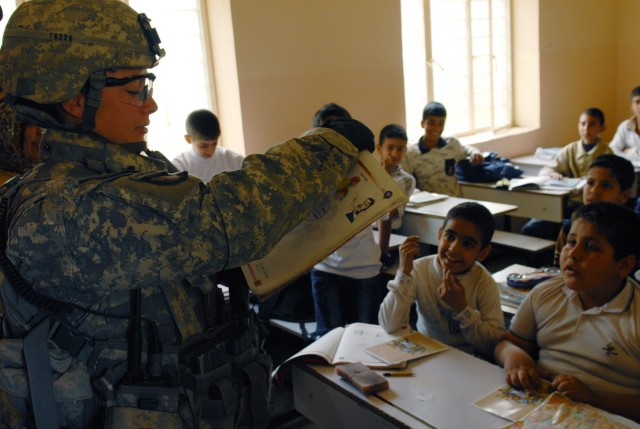 BAGHDAD - Sgt. Krystal Tichenor, team leader, 978th Military Police Company, 93rd MP Battalion, reads from an English book at al-Aldara Primary School, March 31, to test the children's knowledge of English. The 978th, along with Iraqi Policemen,...