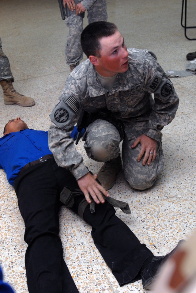 BAGHDAD - Pfc. Paul Seman, a military policeman from Cleveland, with 978th MP Co., demonstrates the proper application of a tourniquet at Scorpion Academy, a training event held at Joint Security Station Salaam. The event covered a wide range of...