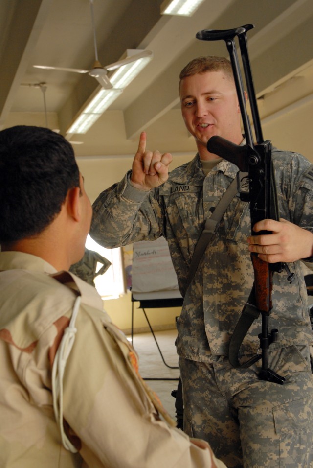 BAGHDAD - Courtland, Va. native Spc. Franklin Land III, a military policeman with 978th MP Co., 93rd MP Bn., inspects an AK-47 and finds it to be satisfactory at Scorpion Academy, a training seminar for Iraqi Army Soldiers and Iraqi Police, March...