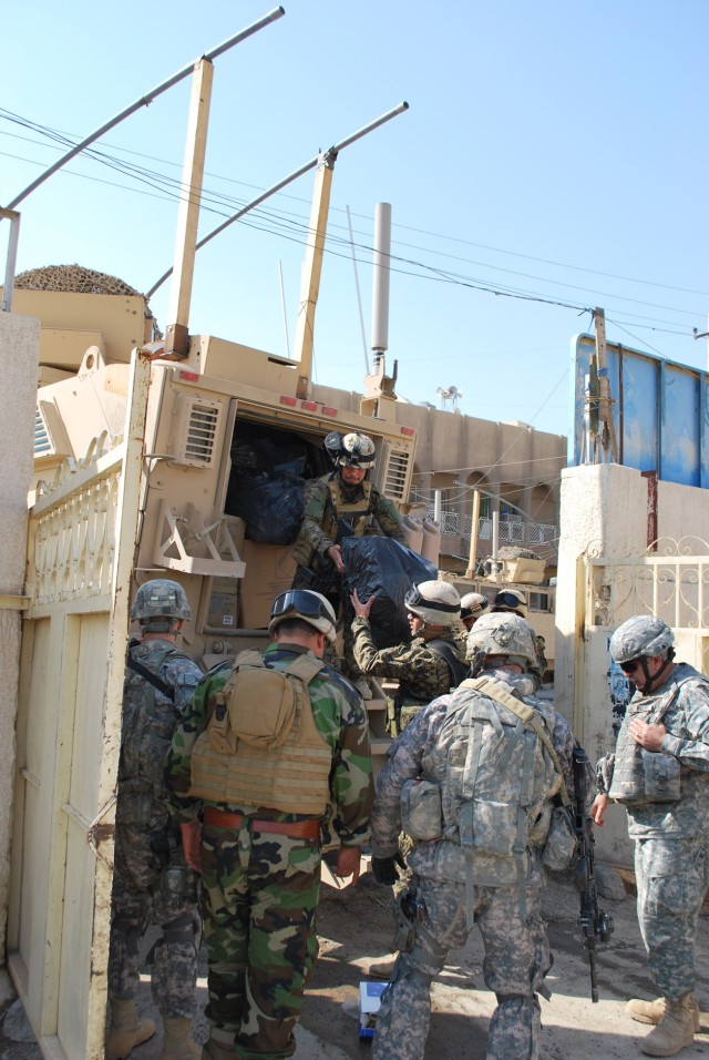 BAGHDAD - Iraqi Army soldiers and Paratroopers assigned to 5th Squadron, 73rd Cavalry Regiment, 3rd Brigade Combat Team, 82nd Airborne Division, Multi-National Division-Baghdad, take out medical supplies from an armored vehicle during a combined...