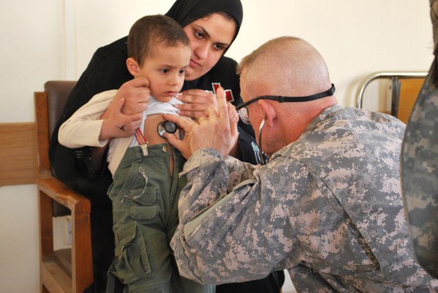 BAGHDAD - Maj. Robert Sexton, of Tucson, Ariz., evaluates an Iraqi boy during a free medical screening April 1 in the al-Fadhil neighborhood. Iraqi Security Forces and Paratroopers assigned to 5th Squadron, 73rd Cavalry Regiment, 3rd Brigade...