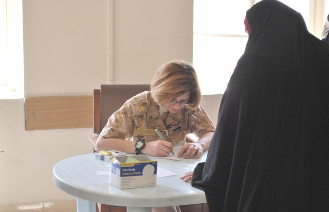 BAGHDAD - An Iraqi Army doctor writes down medical information for an Iraqi woman during a combined humanitarian mission April 1 in the al-Fadhil neighborhood of eastern Baghdad. Paratroopers assigned to 5th Squadron, 73rd Cavalry Regiment, 3rd...