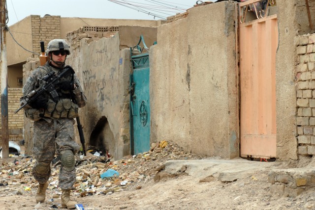 BAGHDAD - Sgt. Brandon Fellers, a native of Fort Dodge, Iowa, and a cannon crewmember assigned to Battery B, 1st Battalion, 319th Airborne Field Artillery Regiment, patrols a neighborhood in Zafaraniyah, Iraq, March 30 during a joint operation....