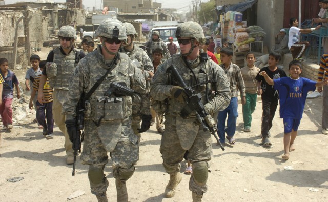 SHAWRA WA UM JIDIR, Iraq - Spc. Ryan Ringi (right), of Suffolk, N.Y., talks to Lt. Col. Michael Shinners, deputy brigade commander of the 3rd Brigade Combat Team, 82nd Airborne Division, Multi-National Division - Baghdad, during a foot patrol...