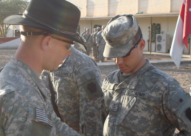 CAMP TAJI, Iraq - Cpt. Nathaniel Lantz (left), of Bound Brooke, N.J., commander of Headquarters and Headquarters Troop, 2nd Squadron, 104th Cavalry, 56th Stryker Brigade Combat Team, 28th Infantry Division, shakes the hand of Pfc. Christopher...