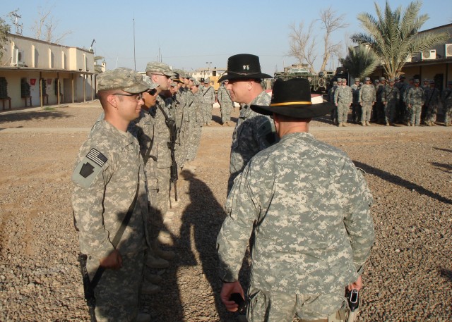 CAMP TAJI, Iraq - Lt. Col. Shawn Reger (right), of Palmyra Pa., commander of 2nd Squadron, 104th Cavalry, 56th Stryker Brigade Combat Team, 28th Infantry Division, talks with soldiers as he hands out the long awaited 28th Division's combat patch....