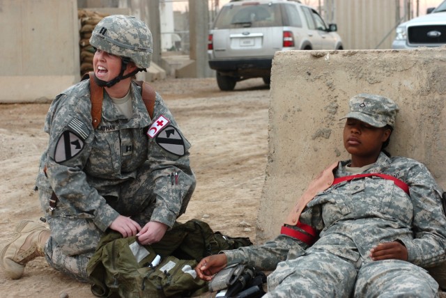 CAMP LIBERTY, Iraq - Killeen, Texas native, Capt. Kimberly Latham (left), a physician's assistant, Division Special Troops Battalion, 1st Cavalry Division, shouts out orders to medics and other Soldiers involved in a mass casualty exercise as she...
