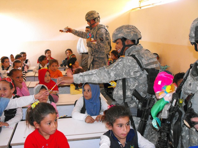 BAGHDAD - Sgt. Natasha Green of Alexandria, La., and Chaplain (Maj.) Jeff Mitchell of Baton Rouge, La., both members of the 225th Engineer Brigade, Multi-National Division - Baghdad hand out school supplies to the students at Um Araybia School in wes...