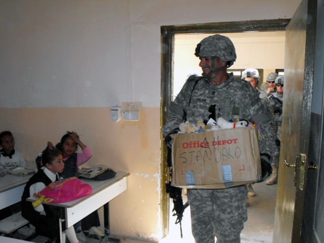 BAGHDAD - Ventress, La. native, Command Sgt. Maj. Joe Major of the 225th Engineer Brigade, Multi-National Division-Baghdad, enters a classroom at the Um Araybia School in western Baghdad carrying a box of stuffed animals he received via donation from...