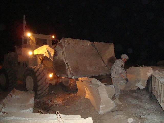 BAGHDAD - Sgt. Ross Maki, 46th Engineer Combat Battalion (Heavy), 225th Engineer Brigade, 1st Cavalry Division, Multi-National Division - Baghdad, from Lake Linden, Mich., utilizes the loader and chains to yank jersey barriers from a trailer for disp...
