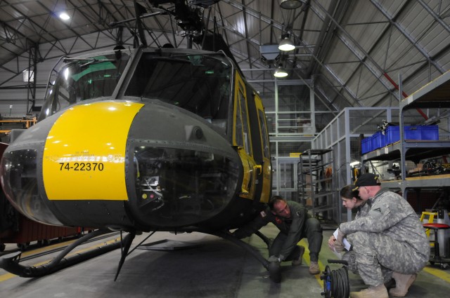 Left to right: Chief Warrant Officer 4 Michael Chickilly, UH-1 standardization pilot and maintenance examiner, walks Maj. Heidi Ridenhour-Jones and Capt. Sam Redding through their pre-flight evaluation March 25 in preparation for their check ride...