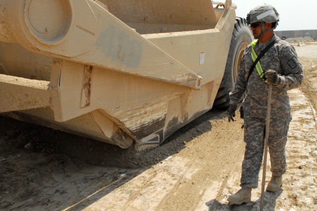 VICTORY BASE COMPLEX, Iraq - San Antonio native, Staff Sgt. David Arispe, of the 277th Engineer Company, attached to the 46th Engineer Battalion, 225th Engineer Brigade, surveys progress made by a heavy equipment  scraper here, April 6, while working...