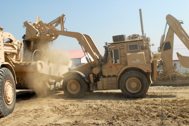 VICTORY BASE COMPLEX, Iraq - A High Mobility Engineer Excavator Type 1 moves excess dirt and ground from one part of the Western Bypass road to be placed at another section of the road, here, April 6.  Spc. Juan Castillo, from San Antonio, a heavy eq...