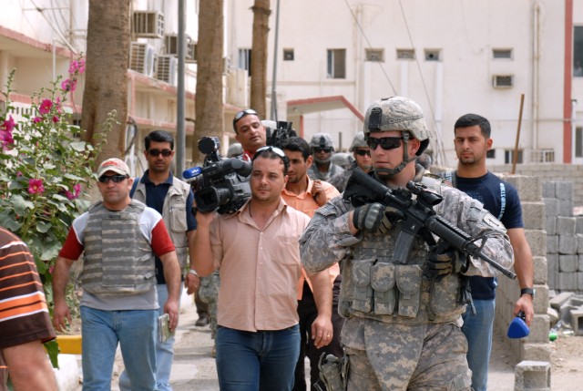 BAGHDAD - Sgt. Michael McNeil, a native of Daytona Beach, Fla., who is a team leader of 2nd Brigade Combat Team, 1st Infantry Division, escorts Iraqi reporters around the site of the future burn center at the Yarmouk Hospital, April 2.  In the backgr...
