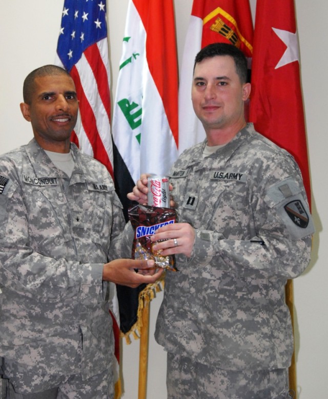 BAGHDAD - Winner of the Brig. Gen. Edmund Giering III outstanding company commander award, Cpt. Jackie Manton (right) of Ponchatoula, La., receives the candy bars and soft drink Giering was known for consuming while deployed. Brig. Gen. Owen...