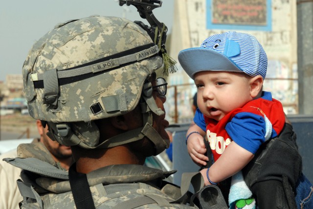 BAGHDAD - Pfc. Gbenga Ayantade, a combat medic from Chicago, assigned to the 1st Battalion, 5th Cavalry Regiment, gives an Iraqi baby a firsthand look at American hospitality April 9. Ayantade, who came to the U.S. in 2007 and is originally from...