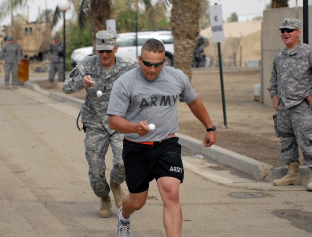 BAGHDAD - Sgt. Tommy Allen of Baton Rouge, La., crosses the finish line ahead of Sgt. Maj. Tommy Brouillette of Pineville, La., both are Soldiers with the 225th Engineer Brigade, during an Easter celebration egg race April 12 on Camp Liberty. The 225...