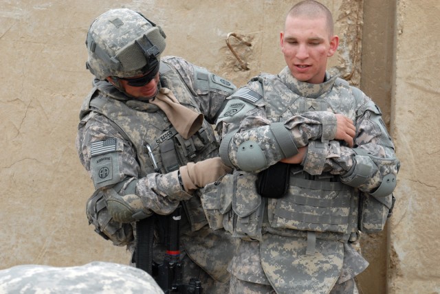 BAGHDAD - Detroit native Spc. Jason Sleeper (left), Company A, Brigade Support Battalion, 3rd Bde., 82nd Airborne Division, does pre-combat checks on Co. A Soldier, Pvt. Timothy Rickett, before a logistics mission, April 6. This is the first...