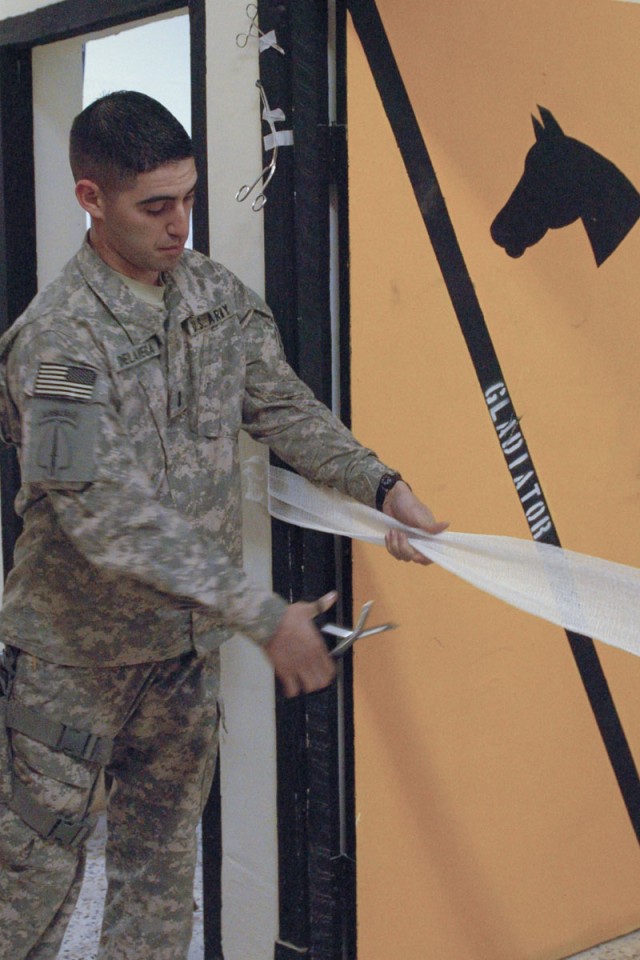 1st Lt. Michael Delavega, physician's assistant for 3rd Brigade, 1st Cav. Div Special Troops Bn. cuts a strip of gauze, used as a ceremonial ribbon, with a pair of bandage scissors to signify the opening of the 3rd Bde. Troop Medical Clinic at...
