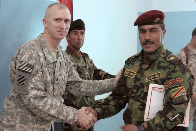 Iraqi Army Lt. Salim Ahmed receives a hearty handshake from Lt. Col. Quinton Arnold, the commander of 3rd Bde., 1st Cav. Div. Special Troops Bn., after receiving a Traffic Control Point Certification course certificate of graduation from Iraqi Army L...