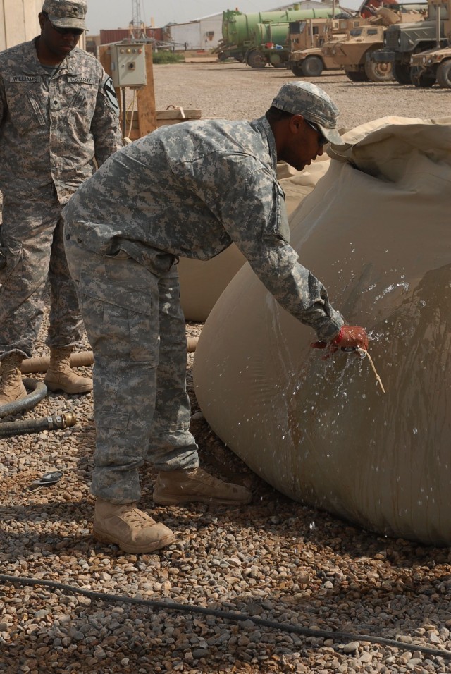 Pvt. Martin Quick, a Colombia, Md. native and a water purification specialist for Company A, 15th Brigade Support Battalion, 2nd Brigade Combat Team, 1st Cavalry Division, attaches a plug to the side of a 3,000 gallon water holding bag to repair mino...