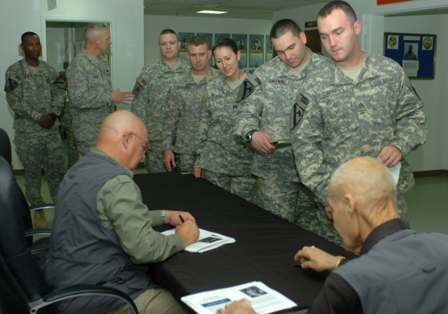 BAGHDAD - Afforded a rare opportunity, Multi-National Division-Baghdad Soldiers stand in line to meet and speak to Medal of Honor recipients, retired Col. Robert L. Howard (right) and retired Command Sgt. Maj. Gary L. Littrell (left) April 14 at Camp...