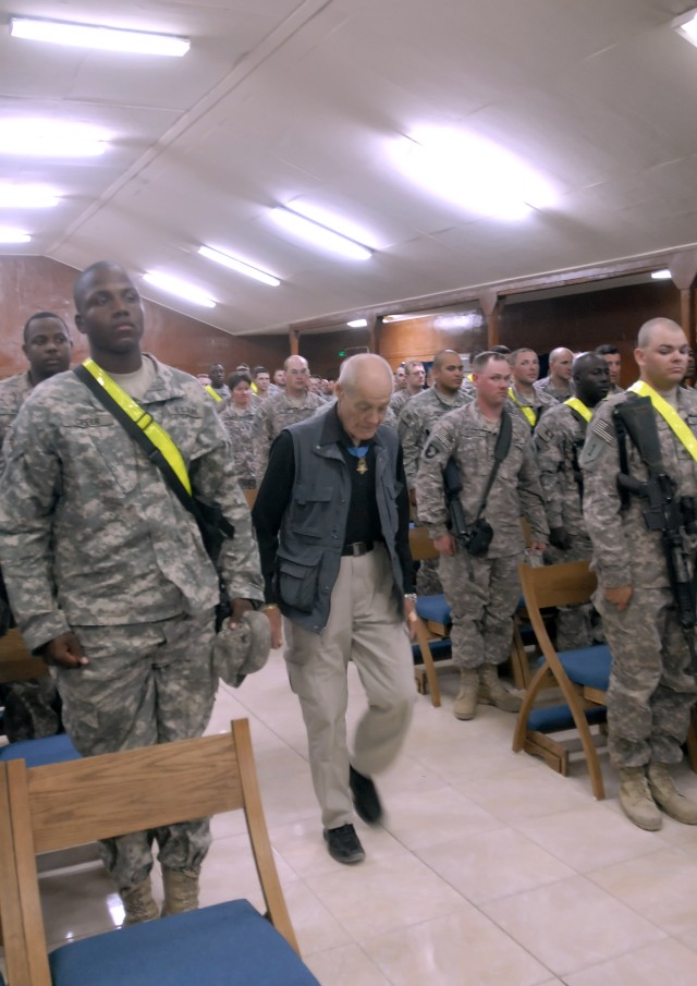 Soldiers serving with the 2nd Heavy Brigade Combat Team, 1st Infantry Division, Multi-National Division - Baghdad, stand at the position of attention while Col. (retired) Robert Howard (center) and Command Sgt. Maj. (retired) Gary Littrell arrive...