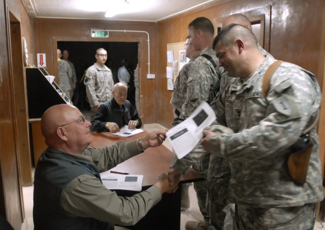 Command Sgt. Maj. (retired) Gary Littrell (left) and Col. (retired) Robert Howard (center), who are Medal of Honor recipients, sign and hand out copies of their Medal of Honor citations to Soldiers serving with the 2nd Heavy Brigade Combat Team, 1st ...